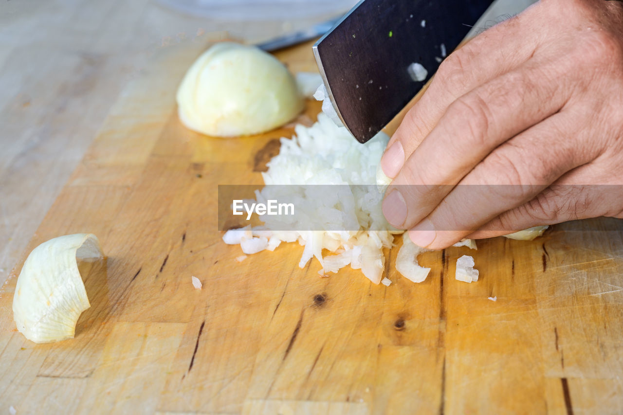 cropped hand of person preparing food on cutting board