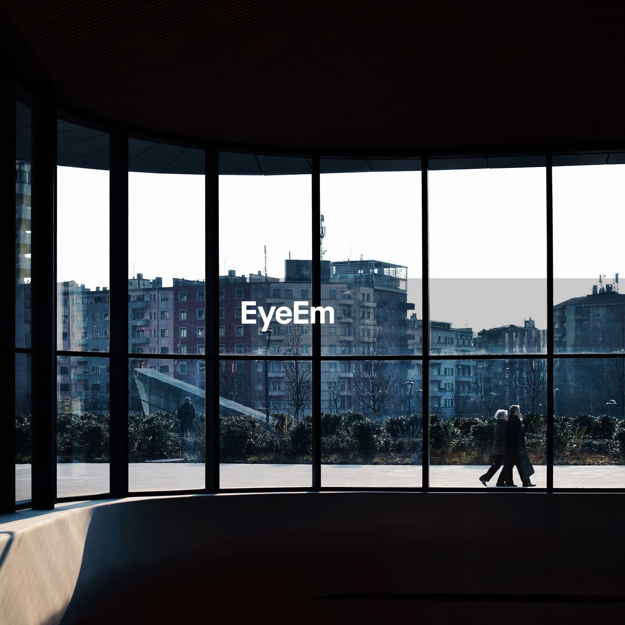 Silhouette man and buildings seen through glass window