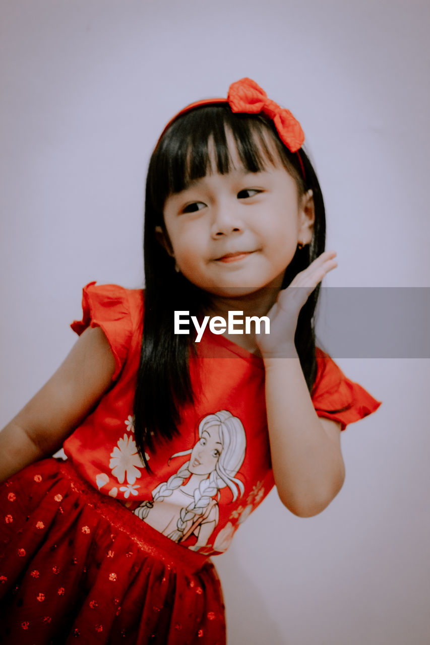 Portrait of girl with red face against gray background