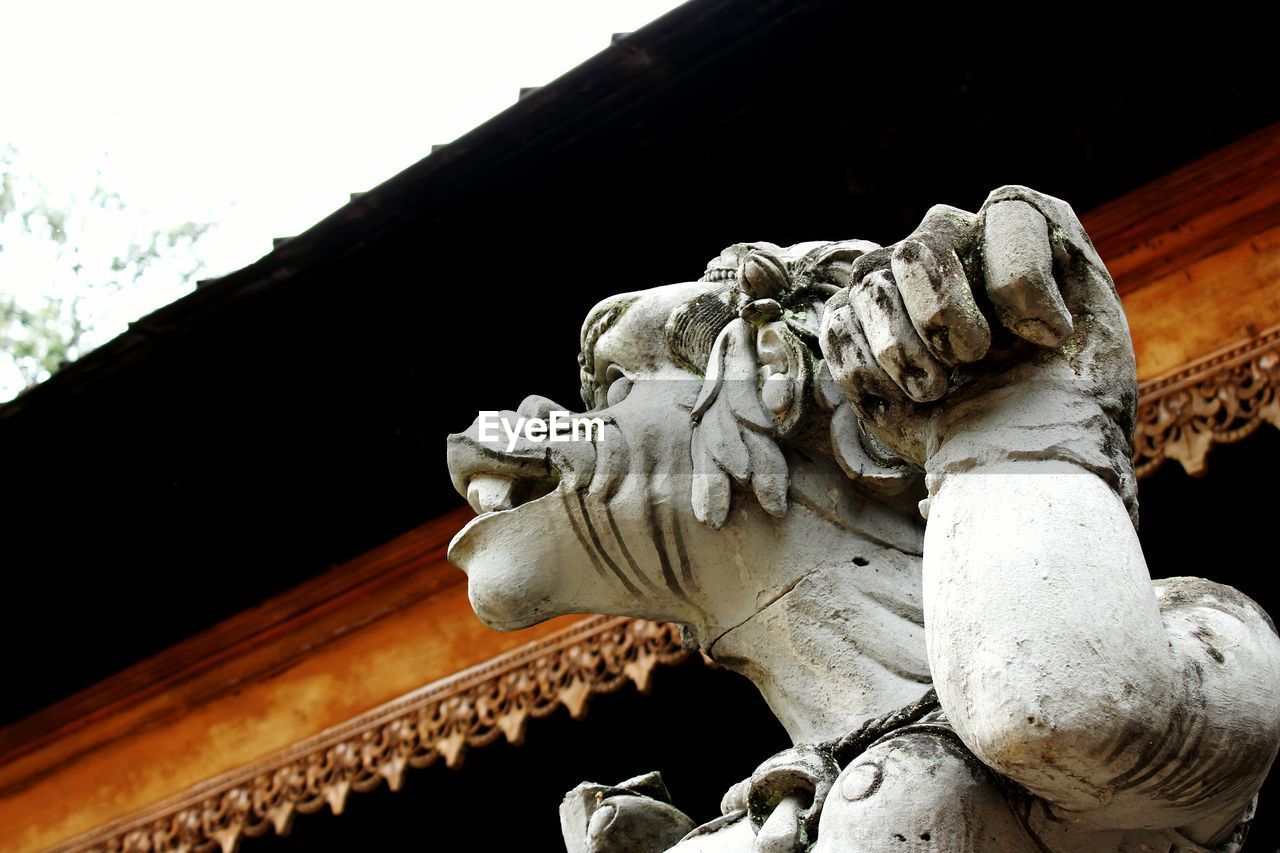 CLOSE-UP OF STATUE AGAINST BUILDING