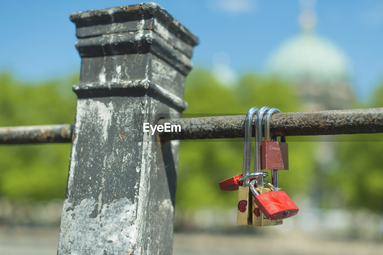 Close-up of padlocks on rusty metallic railing