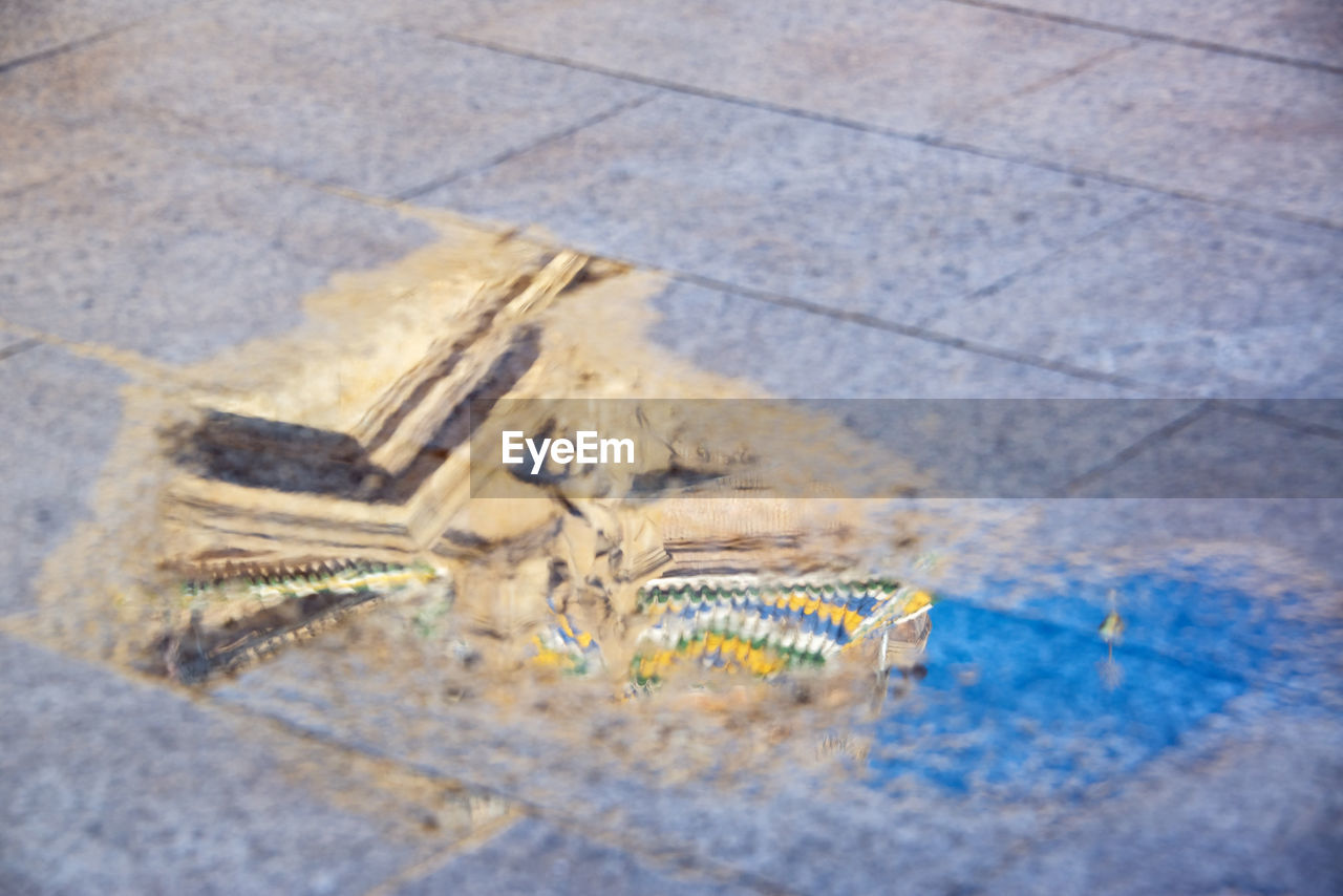 HIGH ANGLE VIEW OF STONES ON FOOTPATH IN CITY