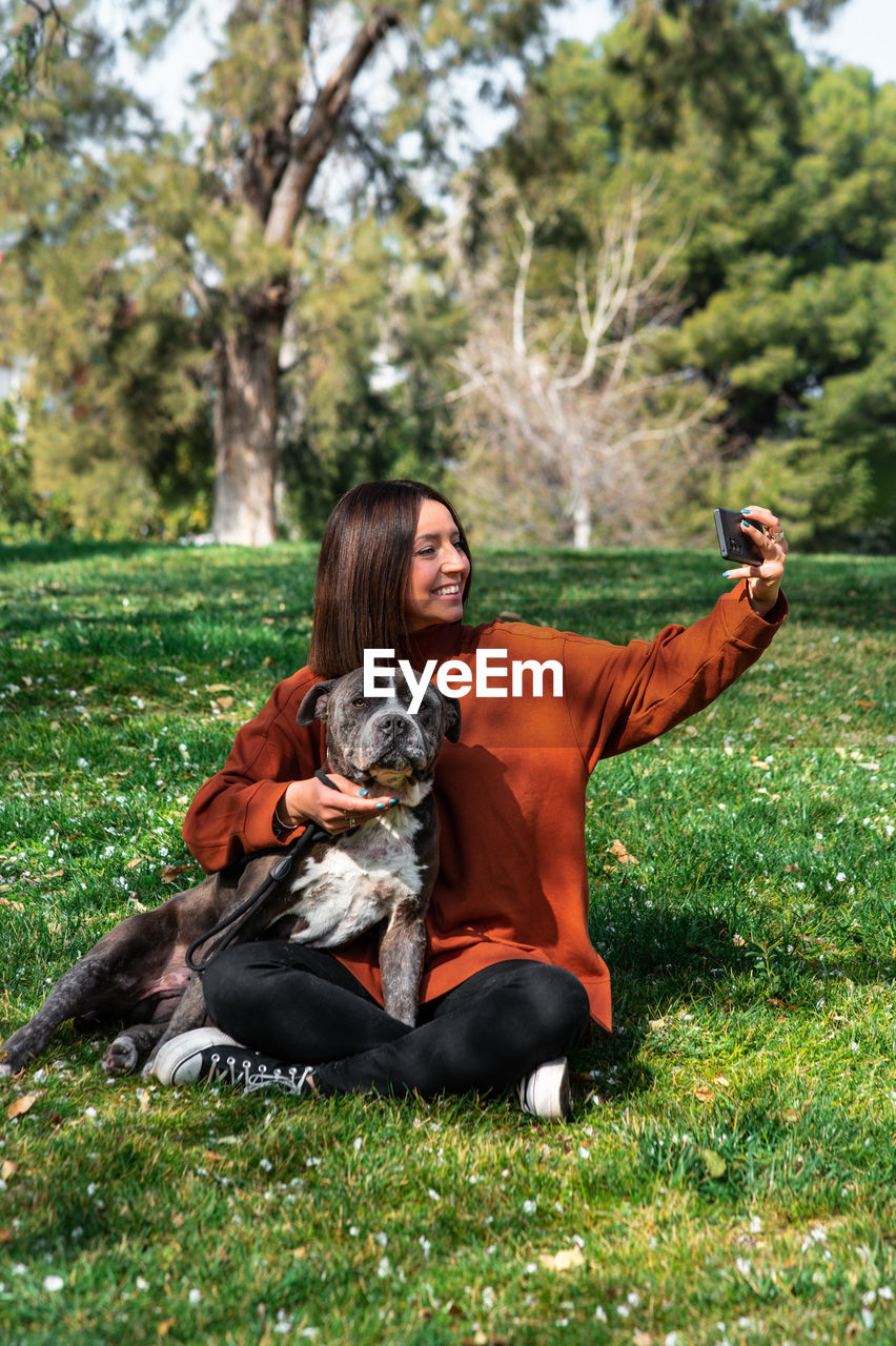 Woman taking selfie with dog at park