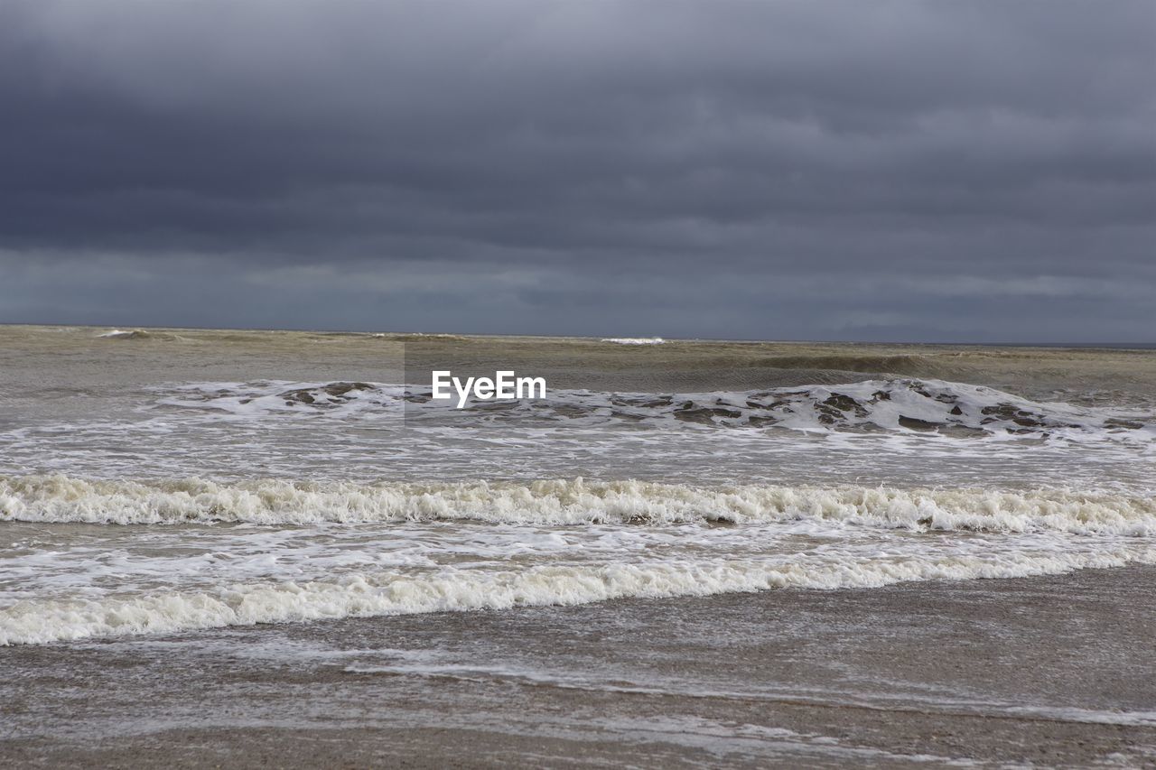 Scenic view of sea against storm clouds