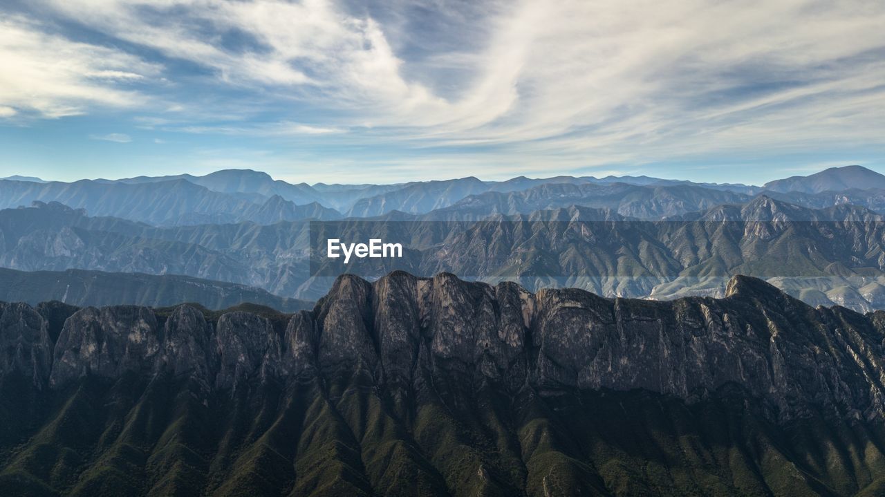 Panoramic view of mountain range against cloudy sky