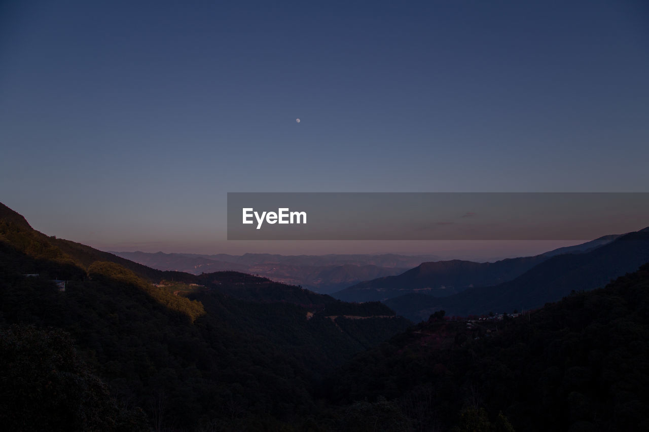 SCENIC VIEW OF SILHOUETTE MOUNTAINS AGAINST SKY AT NIGHT