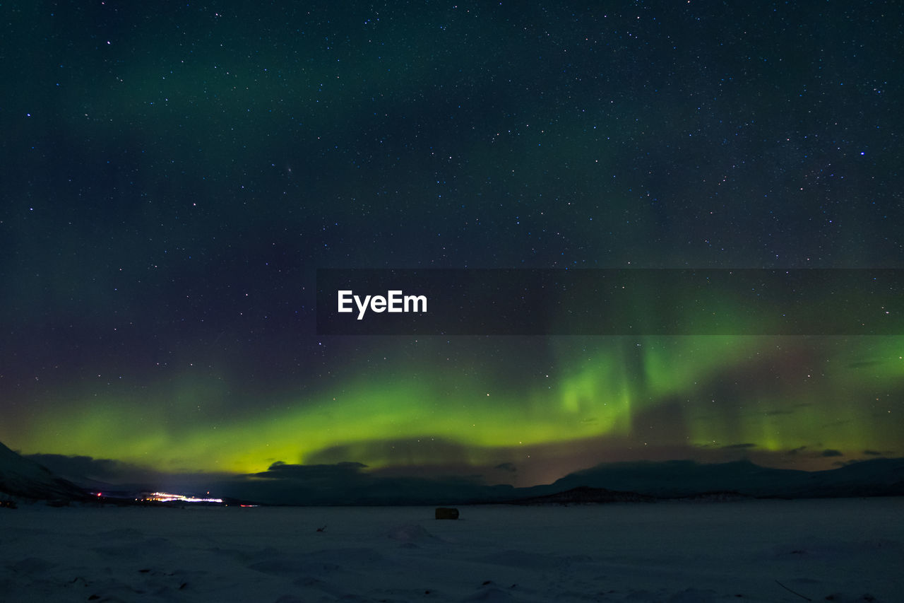 Scenic view of northern lights and star field against sky at night