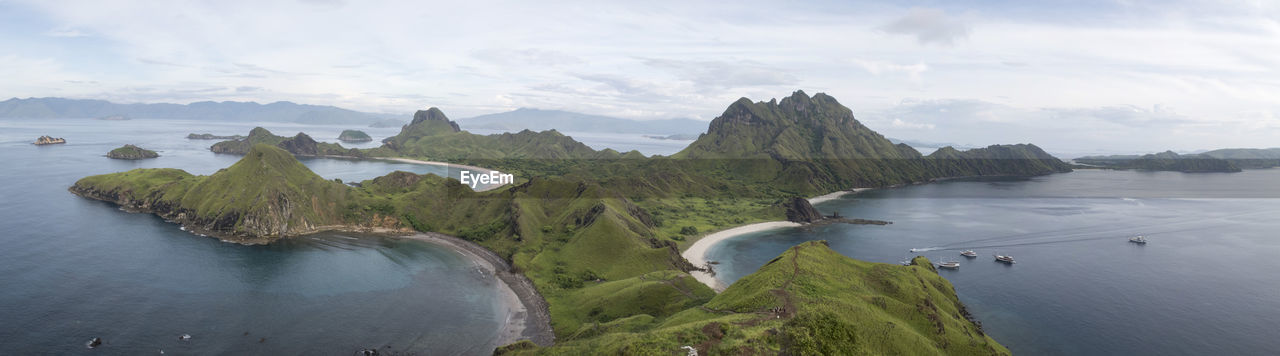 High angle view of sea by mountains against sky