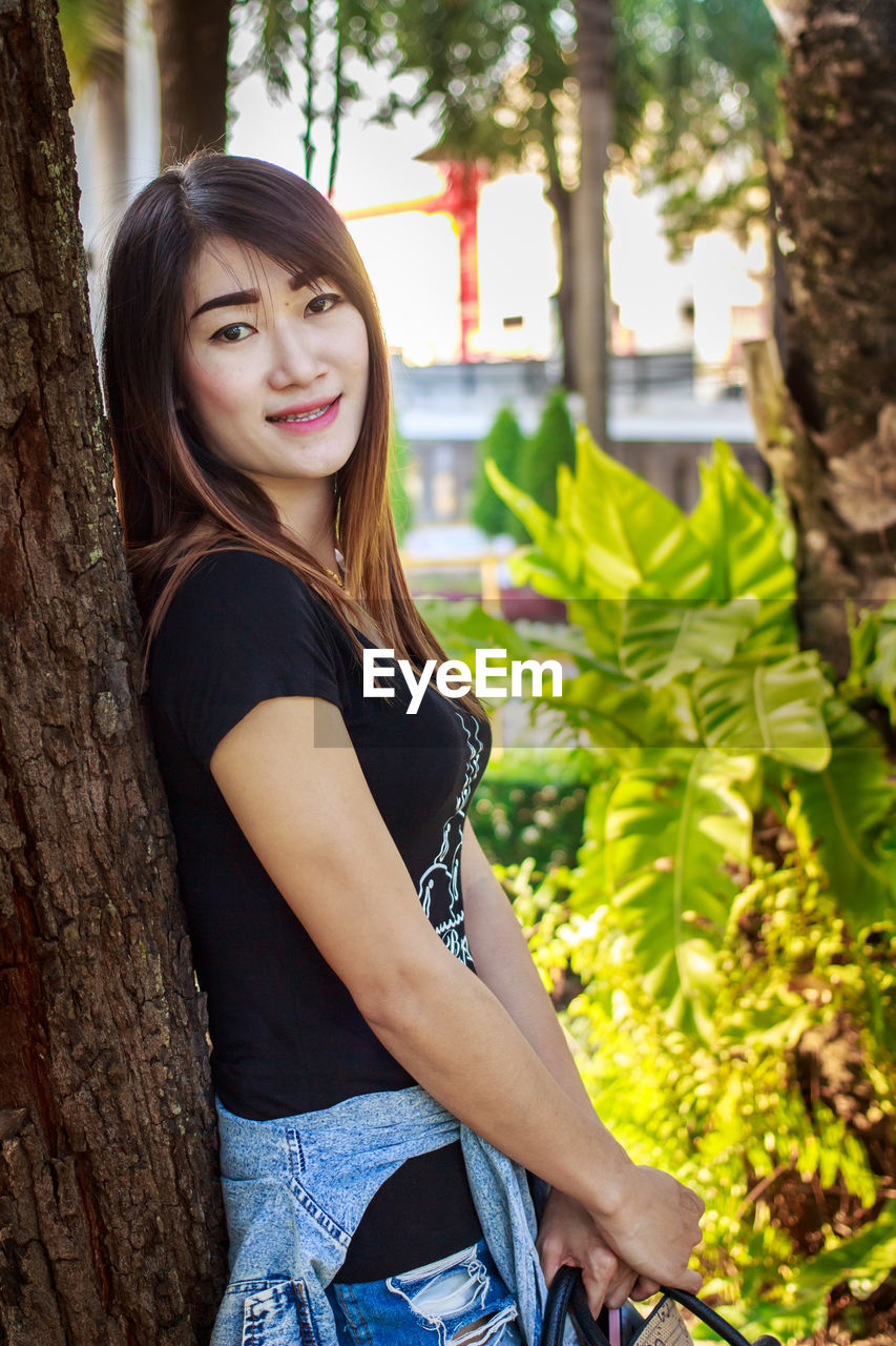 PORTRAIT OF SMILING YOUNG WOMAN