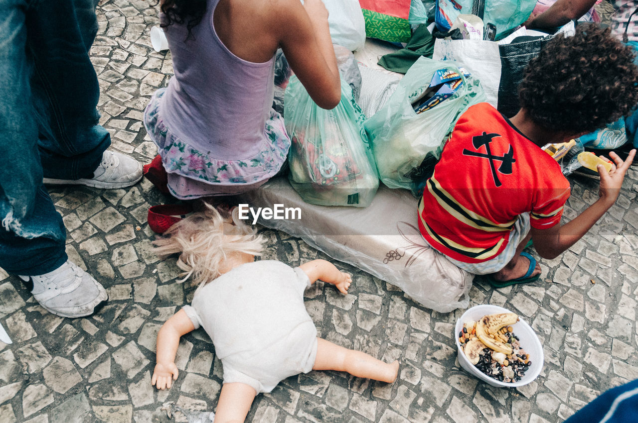 LOW SECTION OF PEOPLE SITTING AT MARKET