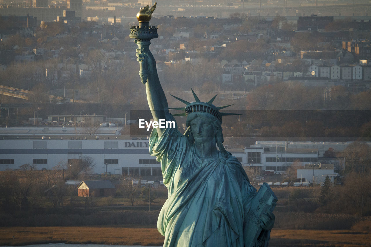 Sunset on the statue of liberty in new york harbor, new york city.