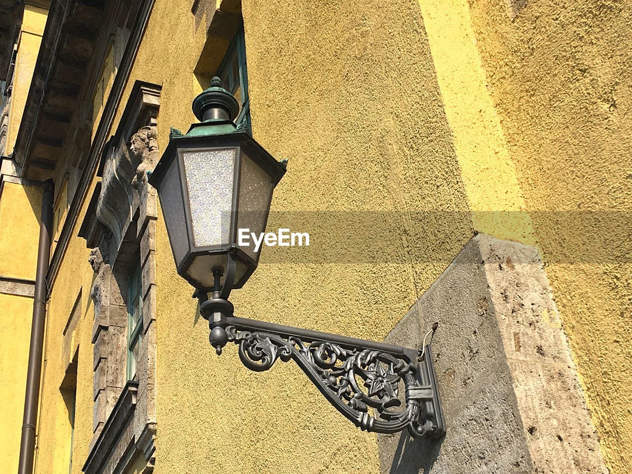 LOW ANGLE VIEW OF STREET LIGHT AGAINST BUILDING WALL
