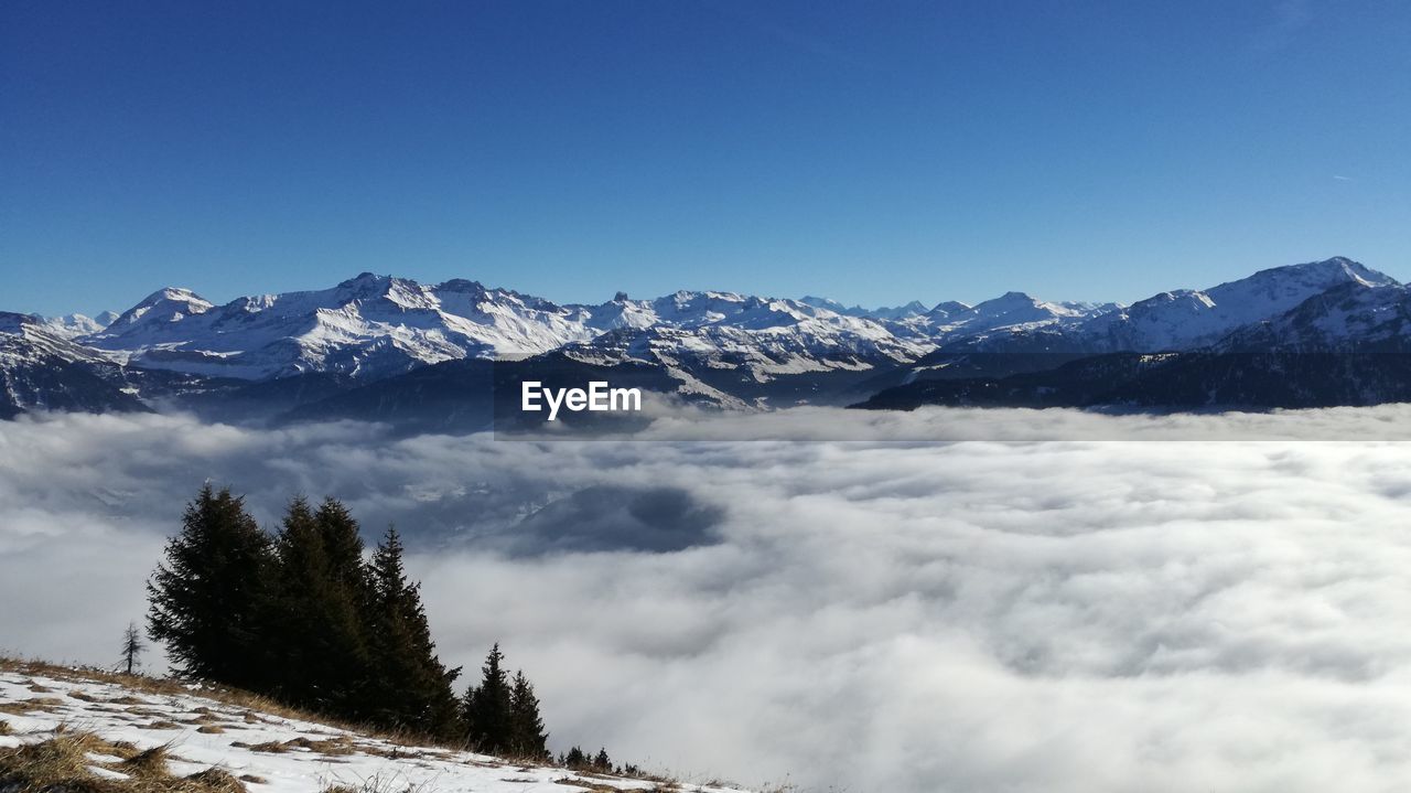 Scenic view of snowcapped mountains against blue sky