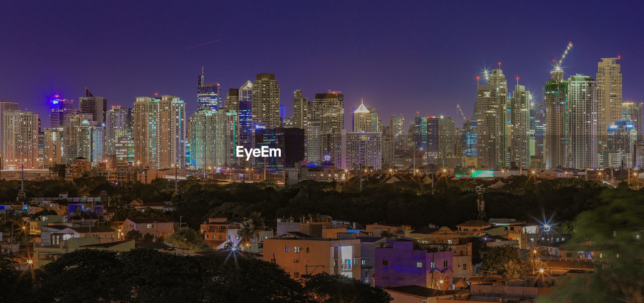 ILLUMINATED BUILDINGS AGAINST SKY AT NIGHT