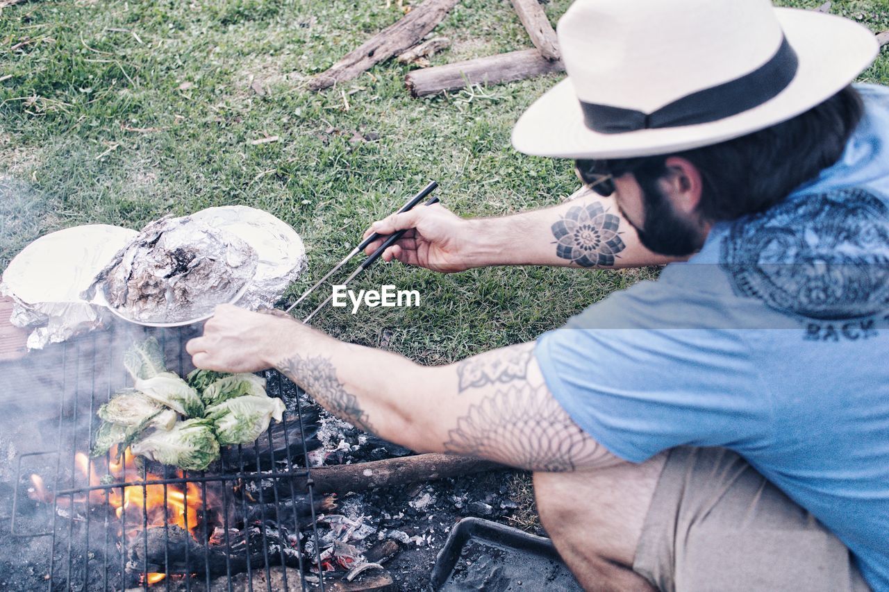 High angle view of man preparing food on barbecue in yard