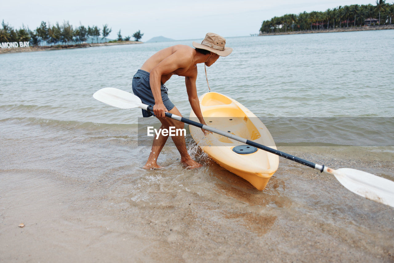 rear view of man kayaking in lake