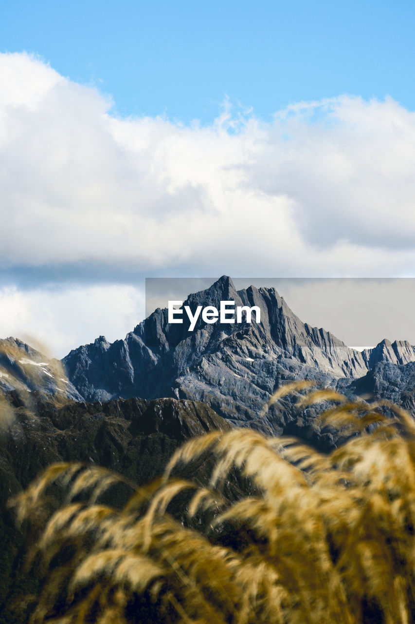 Scenic view of snowcapped mountains against cloudy sky