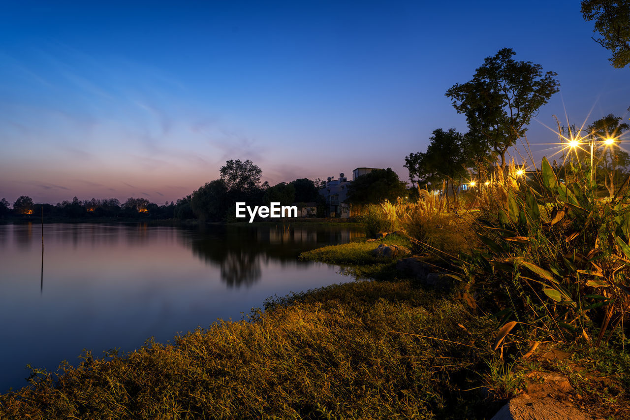 Scenic view of lake against sky at sunset