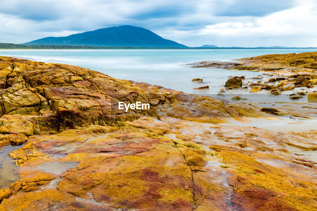 Scenic view of sea and mountains against sky