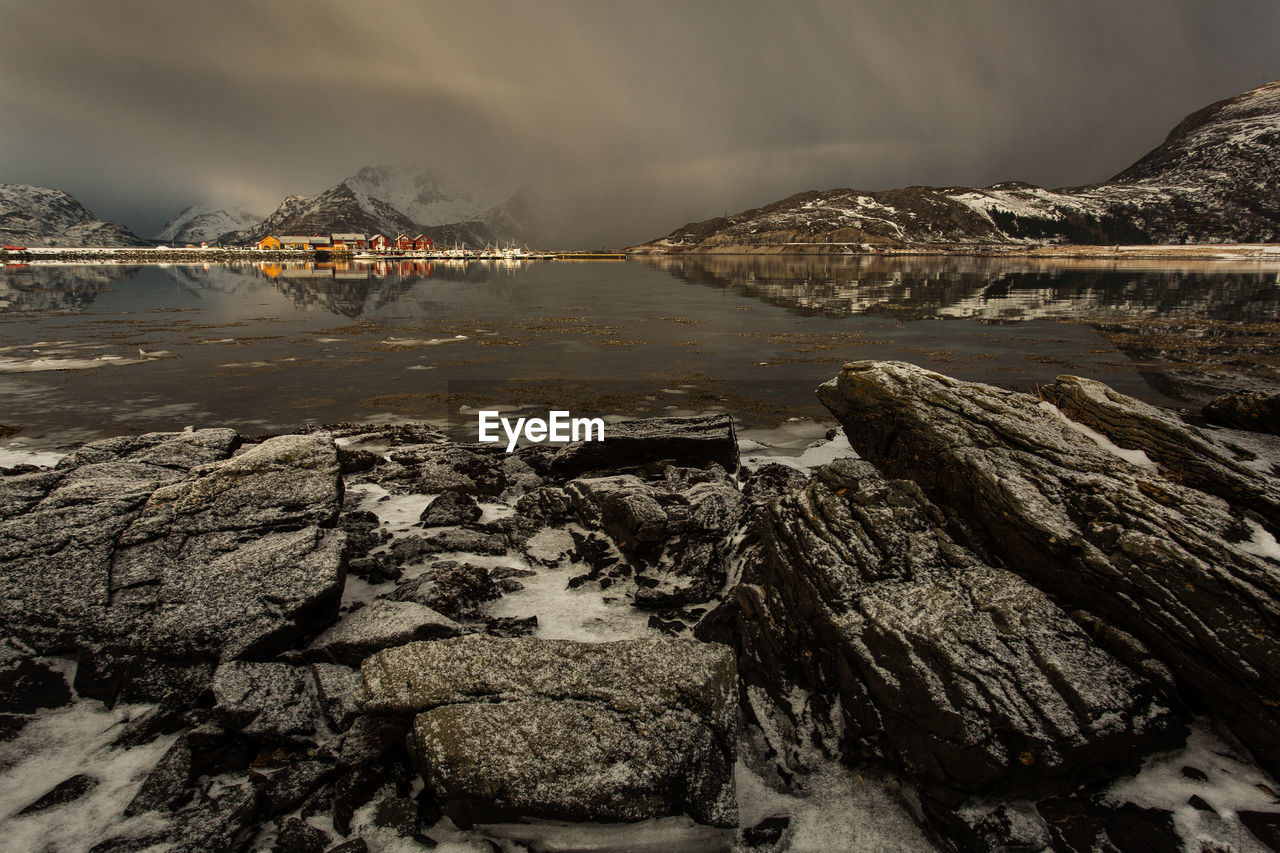 Rock formations by sea against sky during winter