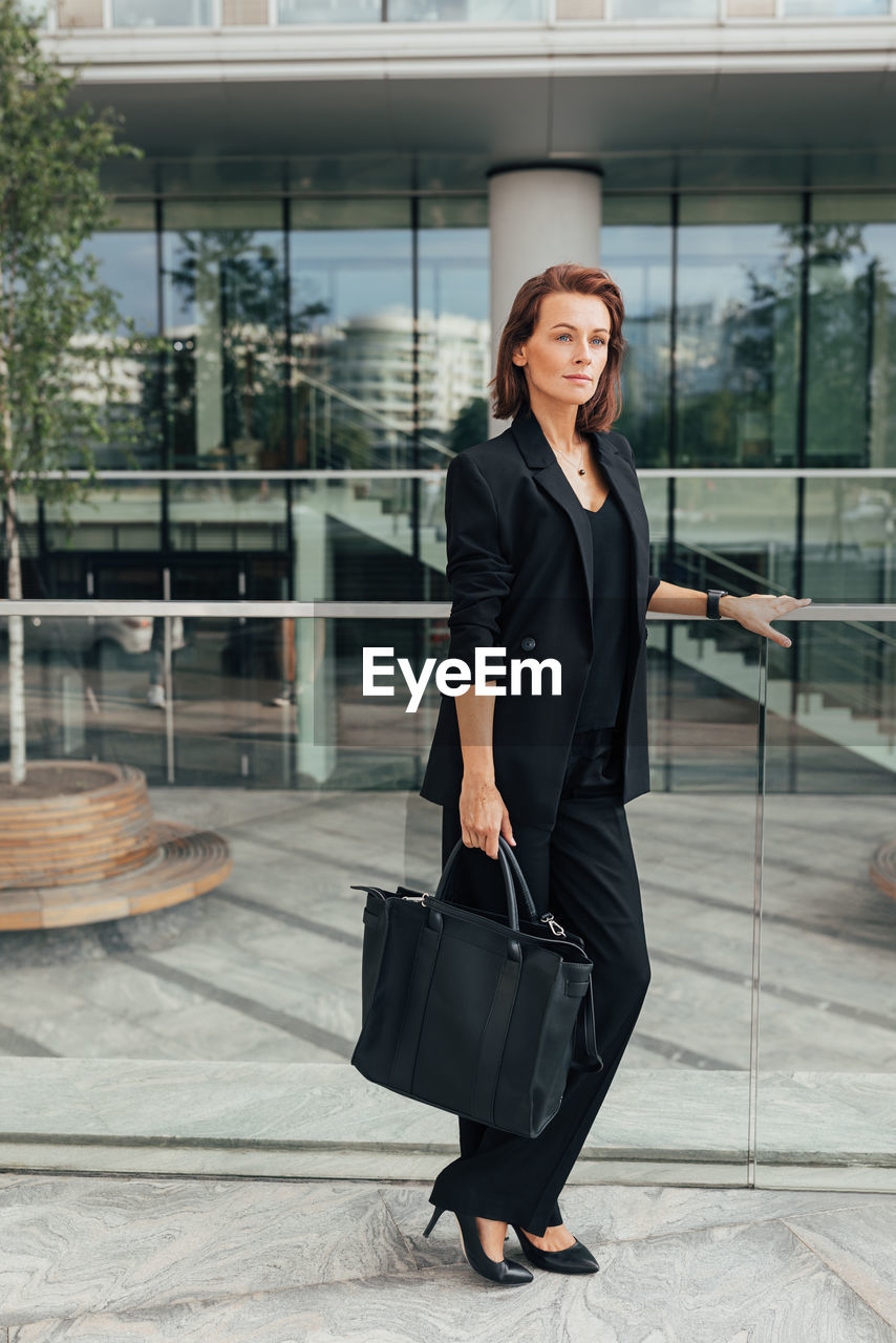 portrait of young businesswoman standing in city