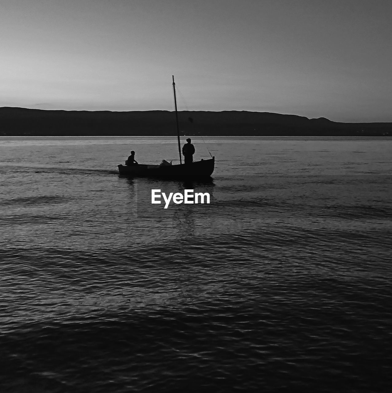 SILHOUETTE PEOPLE ON BOAT AGAINST SEA