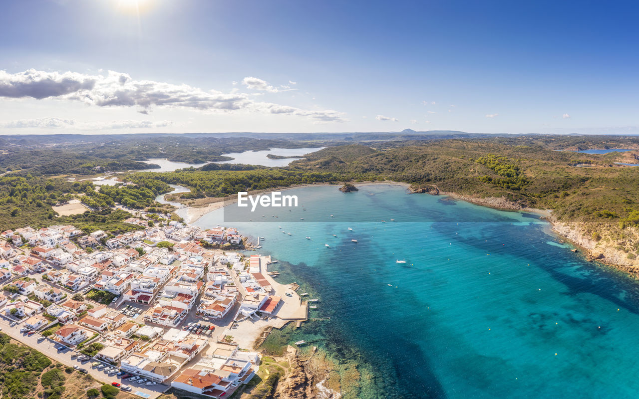 Spain, balearic islands, menorca, aerial view of bay in front of coastal village in summer