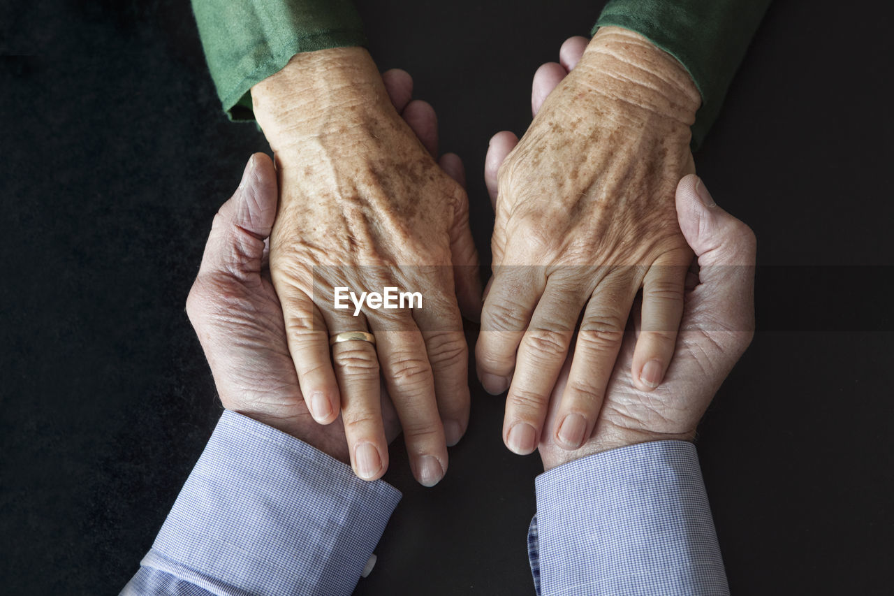 Senior couple holding hands, close-up