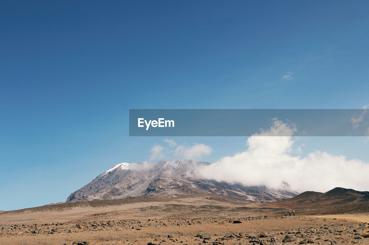 Barren landscape with mountain against sky
