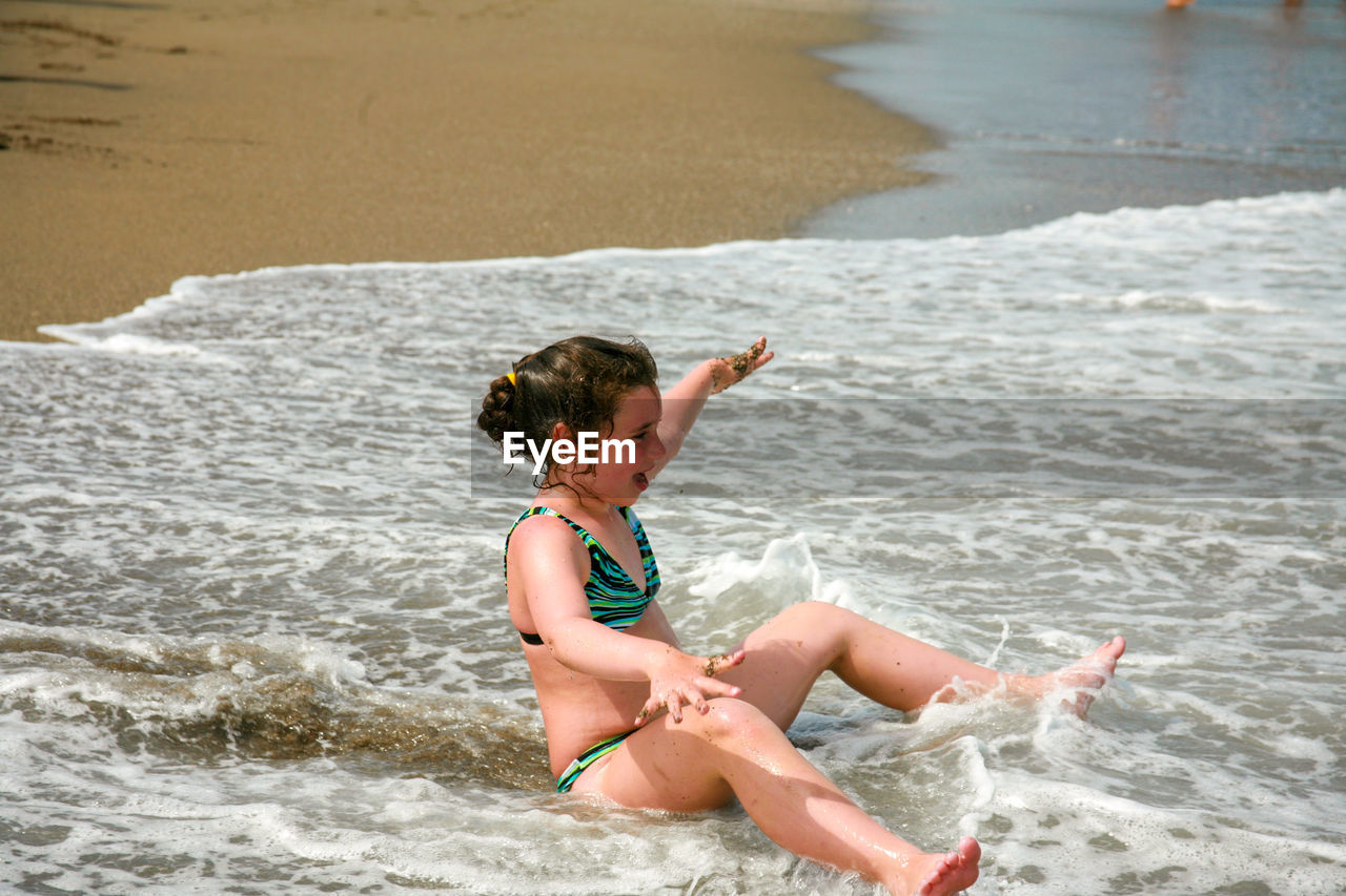 High angle view of girl enjoying at beach