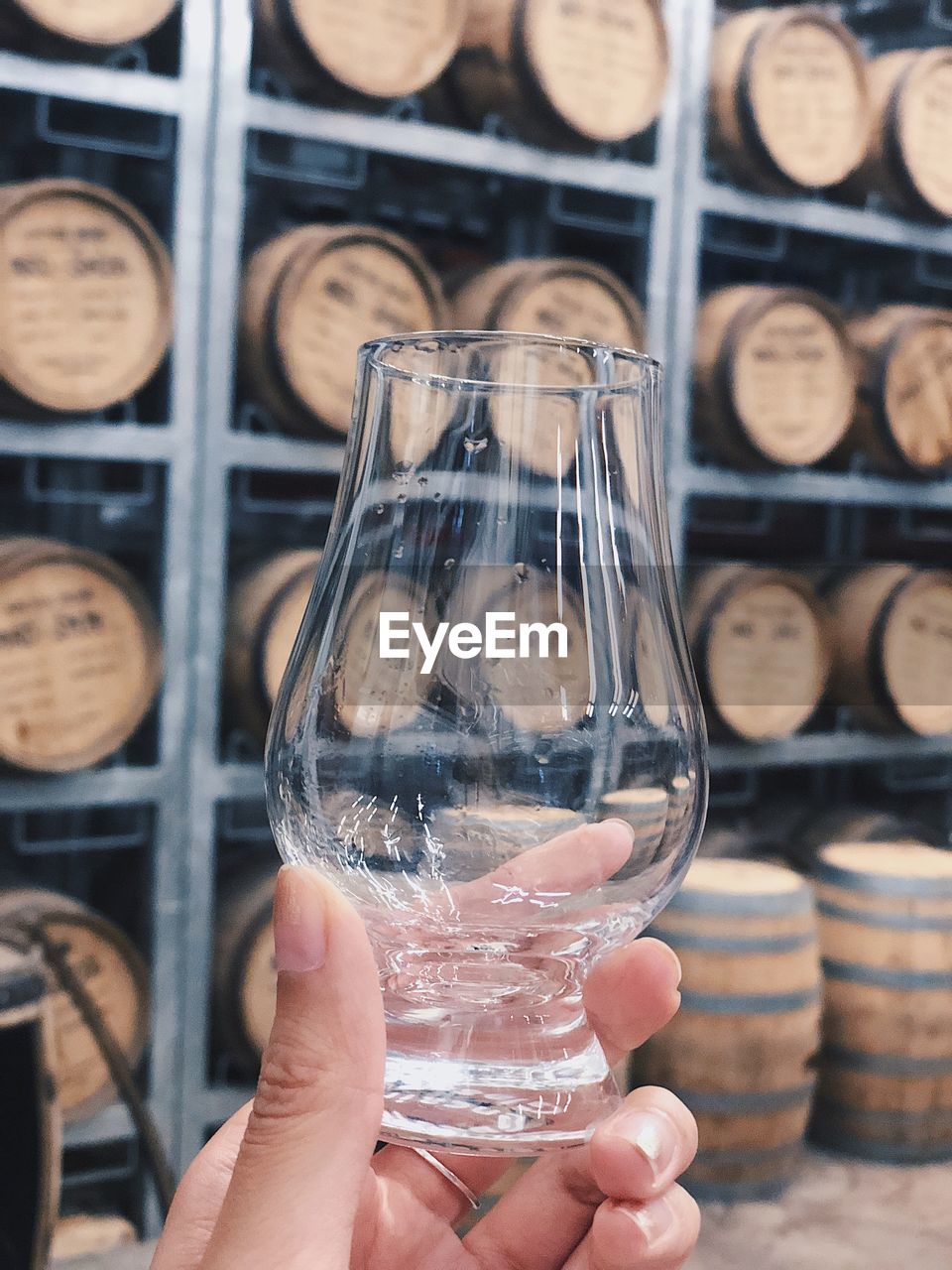 Close-up of hand holding drinking glass at brewery