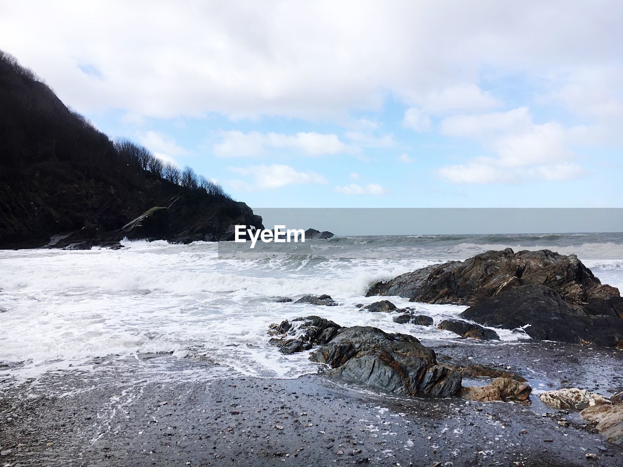 SCENIC VIEW OF ROCKS ON SHORE AGAINST SKY