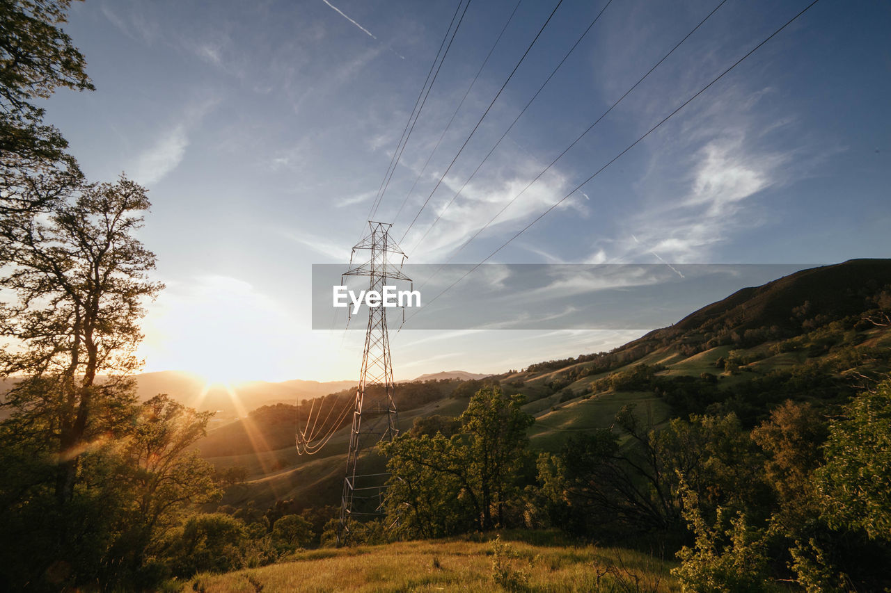 sky, nature, sunlight, environment, cable, morning, electricity, landscape, technology, electricity pylon, scenics - nature, cloud, mountain, plant, tree, power line, beauty in nature, land, power supply, power generation, sun, dusk, no people, light, horizon, tranquility, rural area, sunrise, non-urban scene, sunbeam, tranquil scene, outdoors, rural scene, lens flare, forest, environmental conservation, silhouette, architecture, idyllic, autumn, back lit, blue, reflection, mountain range
