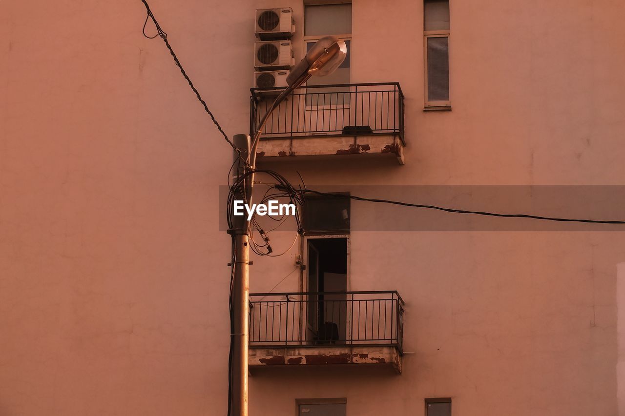 architecture, built structure, building exterior, wall, building, house, fire escape, no people, wall - building feature, railing, low angle view, residential district, iron, staircase, window, steps and staircases, day, outdoors, balcony, stairs, facade, lighting, city