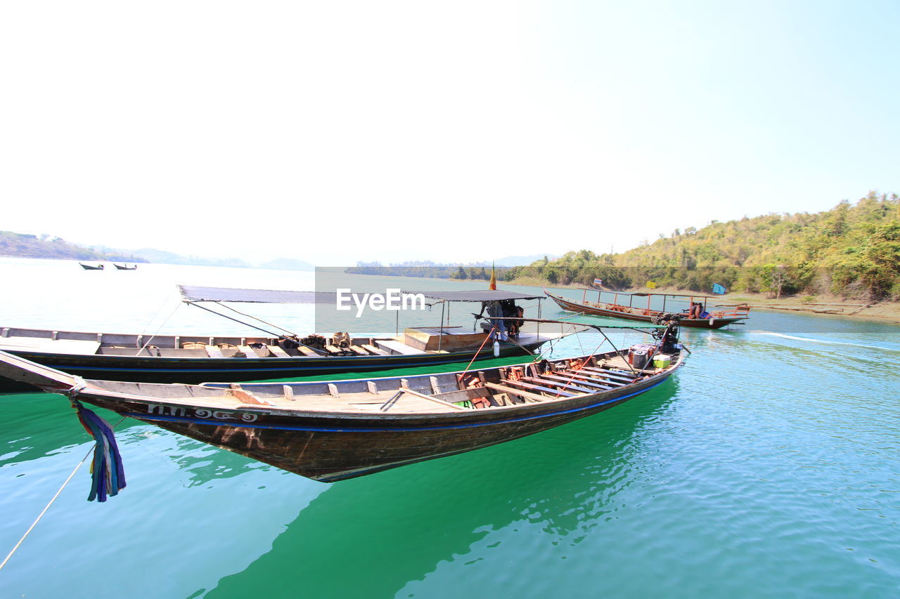 Boat moored on sea against clear sky