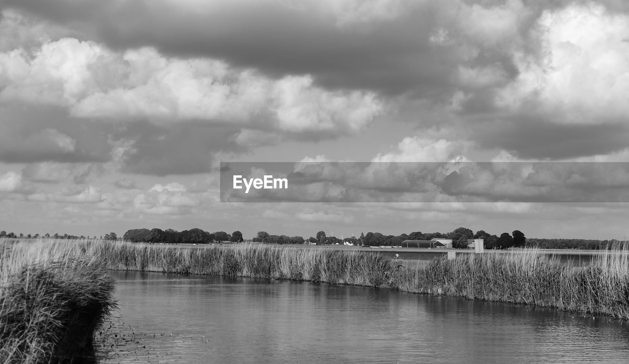 cloud, water, sky, black and white, monochrome photography, environment, nature, monochrome, landscape, scenics - nature, plant, beauty in nature, reflection, no people, tree, tranquility, lake, horizon, land, outdoors, tranquil scene, day, travel destinations, overcast, non-urban scene, travel, cloudscape, architecture, grass, rural scene, storm