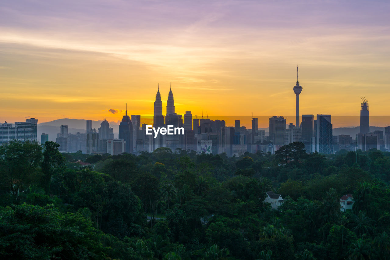 View of city against cloudy sky during sunset