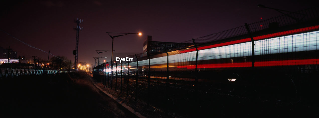 TRAIN ON RAILROAD TRACKS AT NIGHT