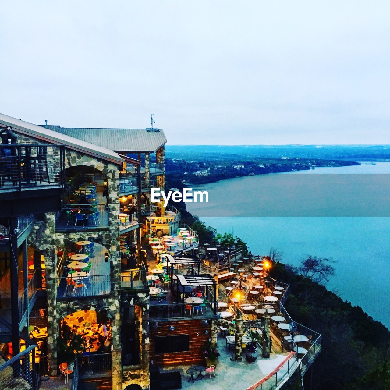 High angle view of illuminated cityscape by sea against sky