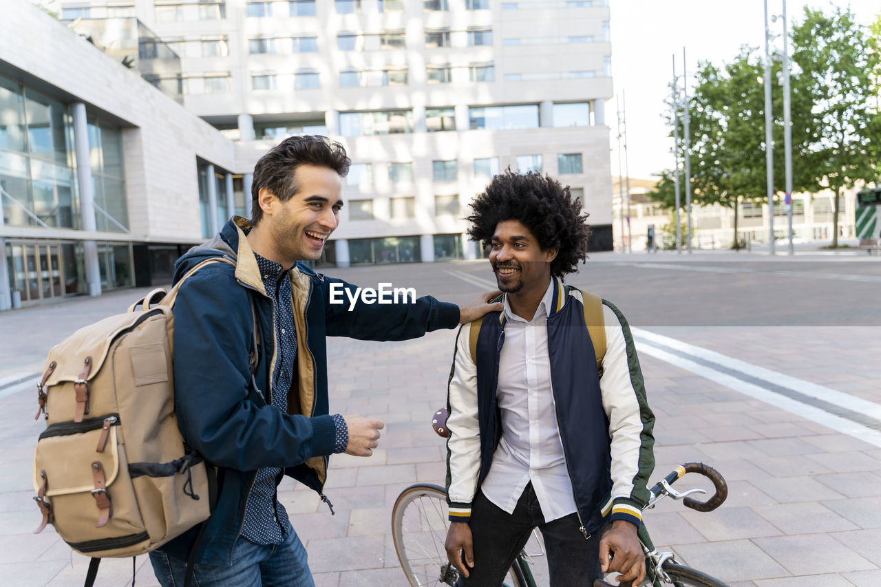 Two happy casual businessmen meeting in the city, barcelona, spain