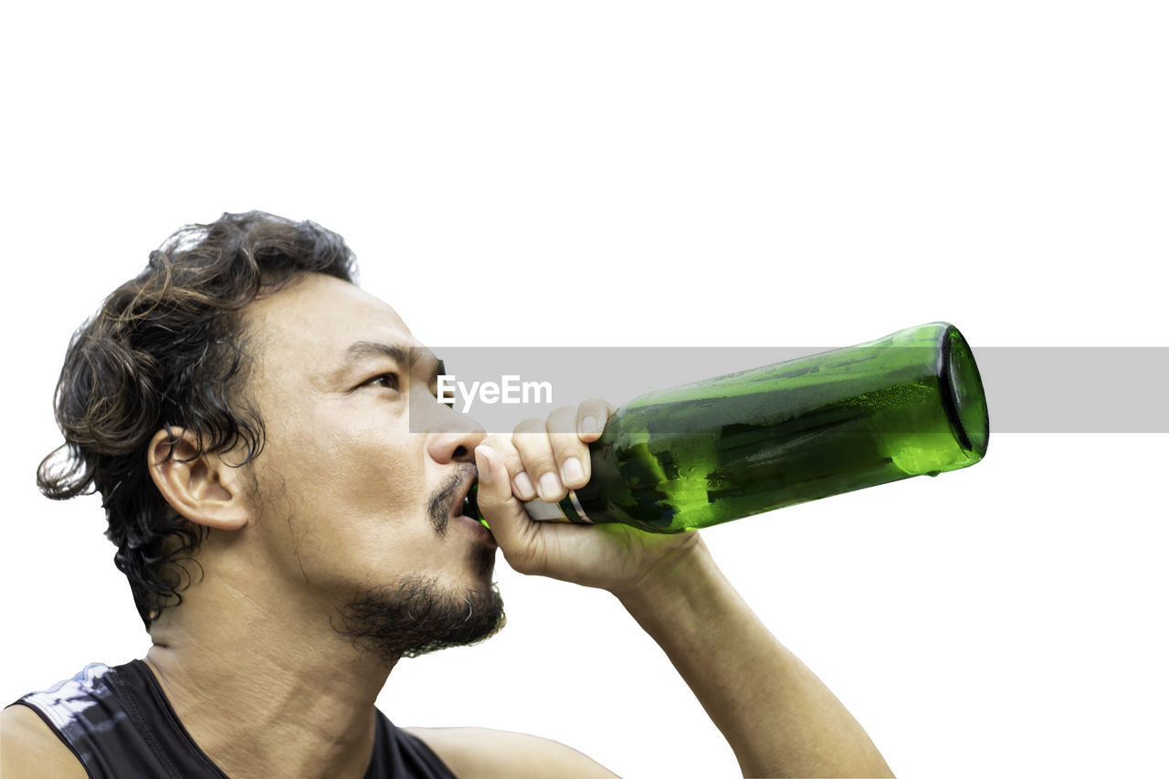 PORTRAIT OF YOUNG MAN DRINKING BEER