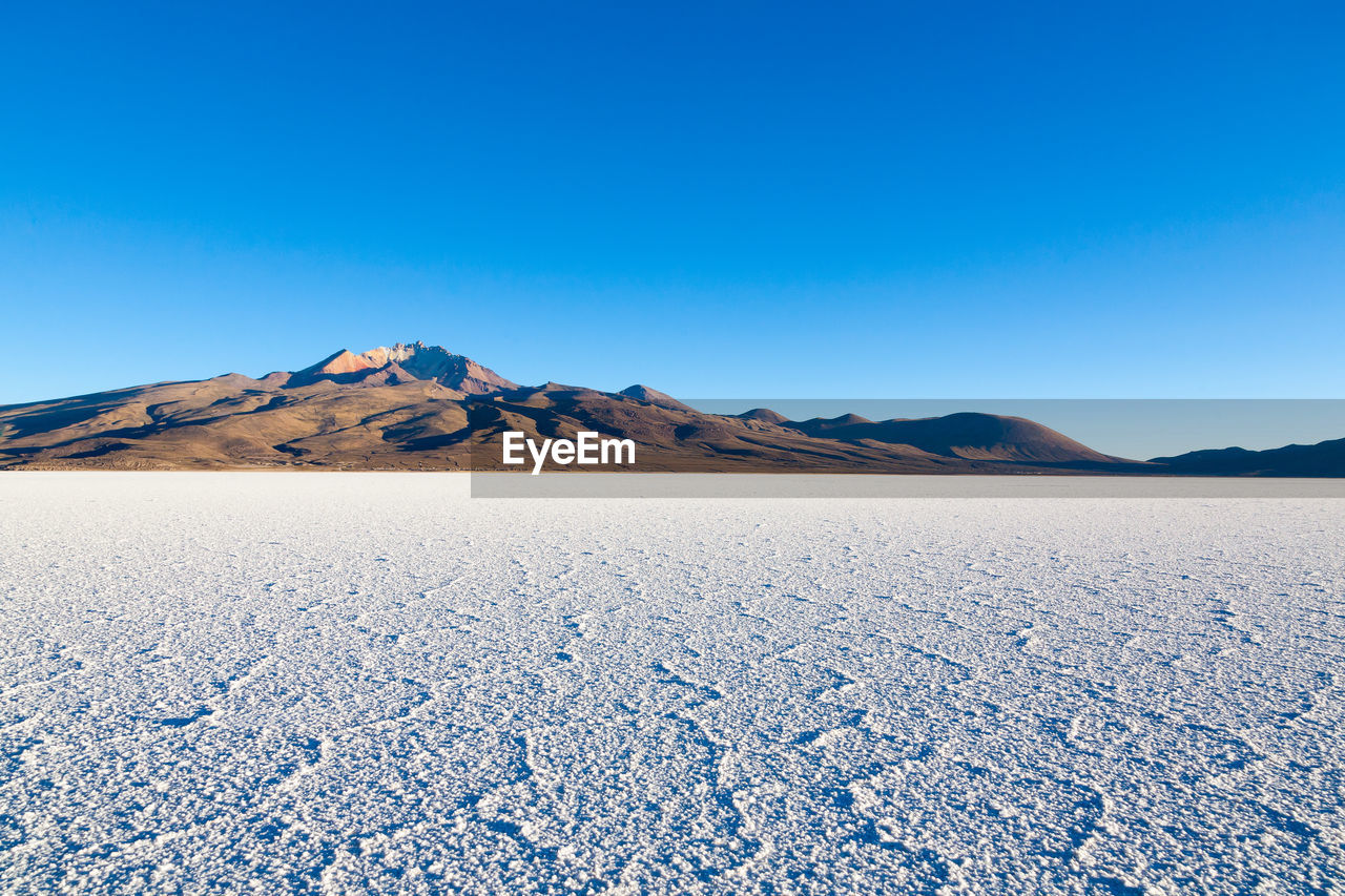 scenic view of desert against clear blue sky