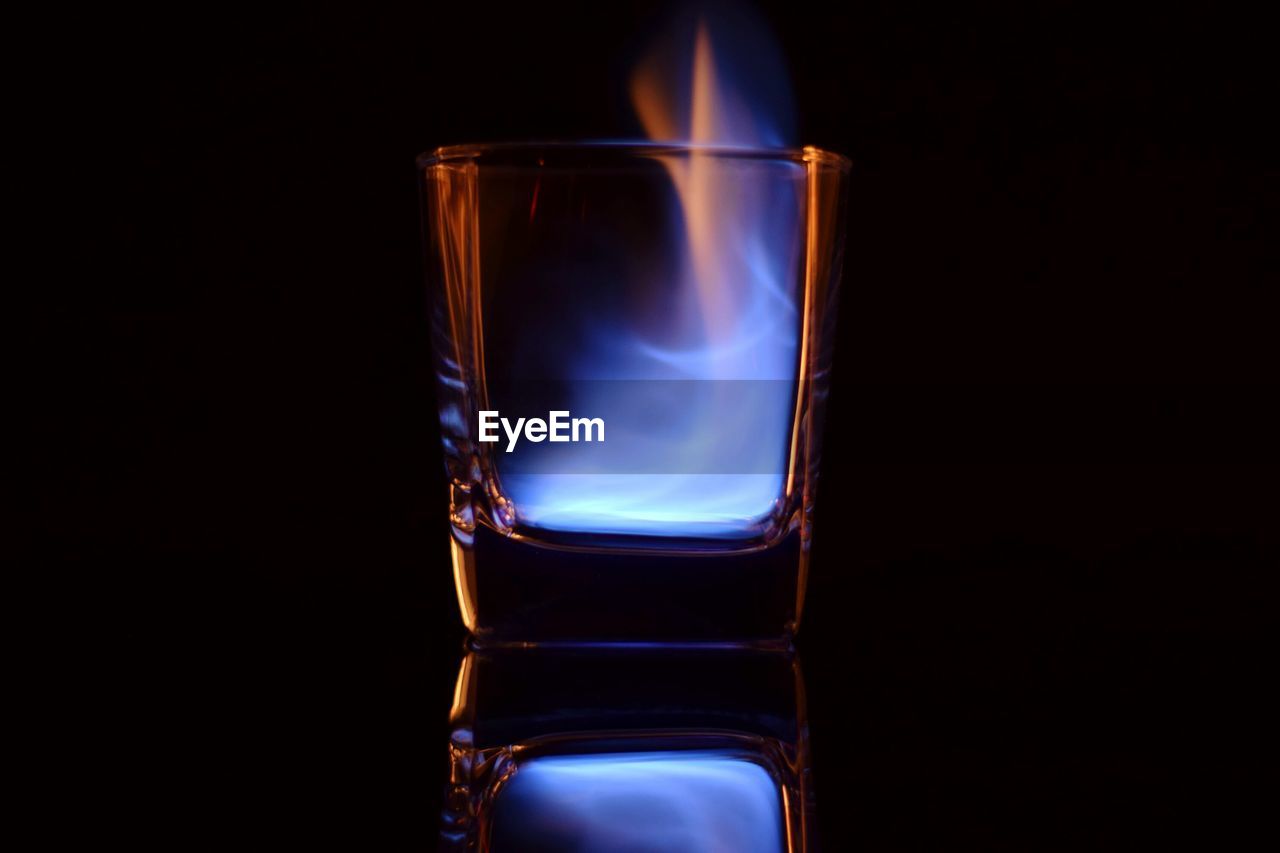 Close-up of fire in glass against black background
