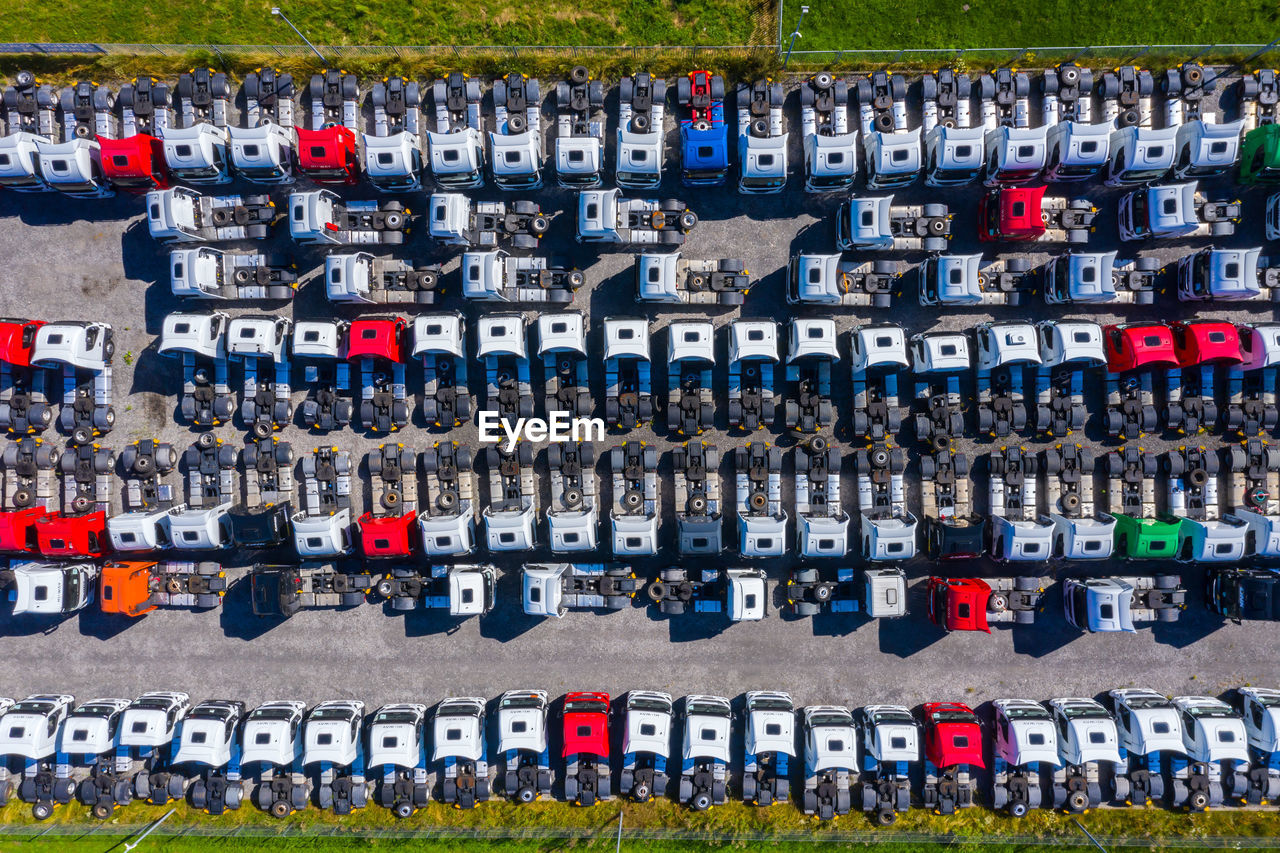 Lots of freight trailers. cars are in several rows. truck parking. aerial view vertically down.