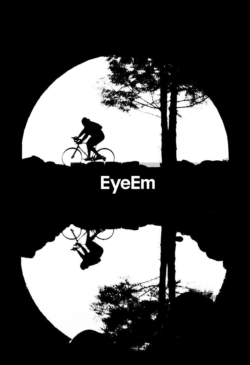 SILHOUETTE OF MAN RIDING BICYCLE AGAINST SKY