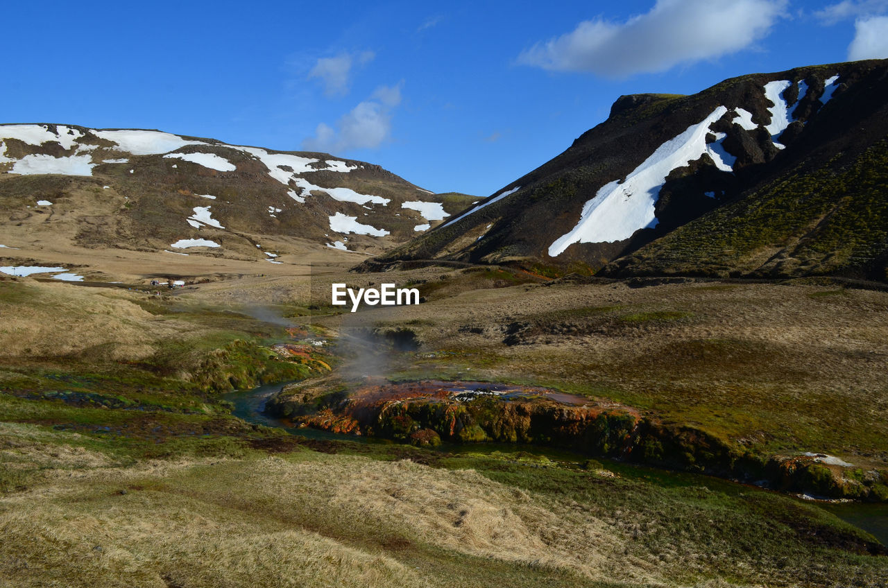 Hot steam rising from a flowing hot spring in rural iceland.