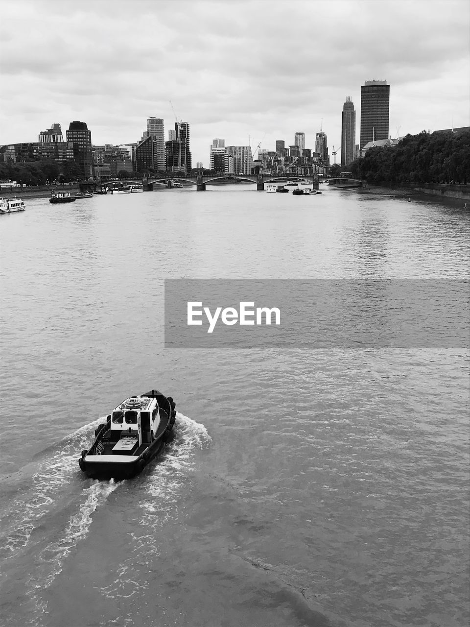 Boat sailing on sea against buildings in city