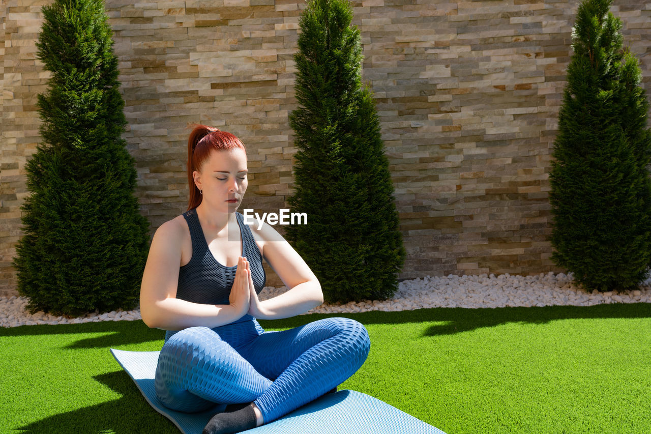 portrait of young woman sitting on field