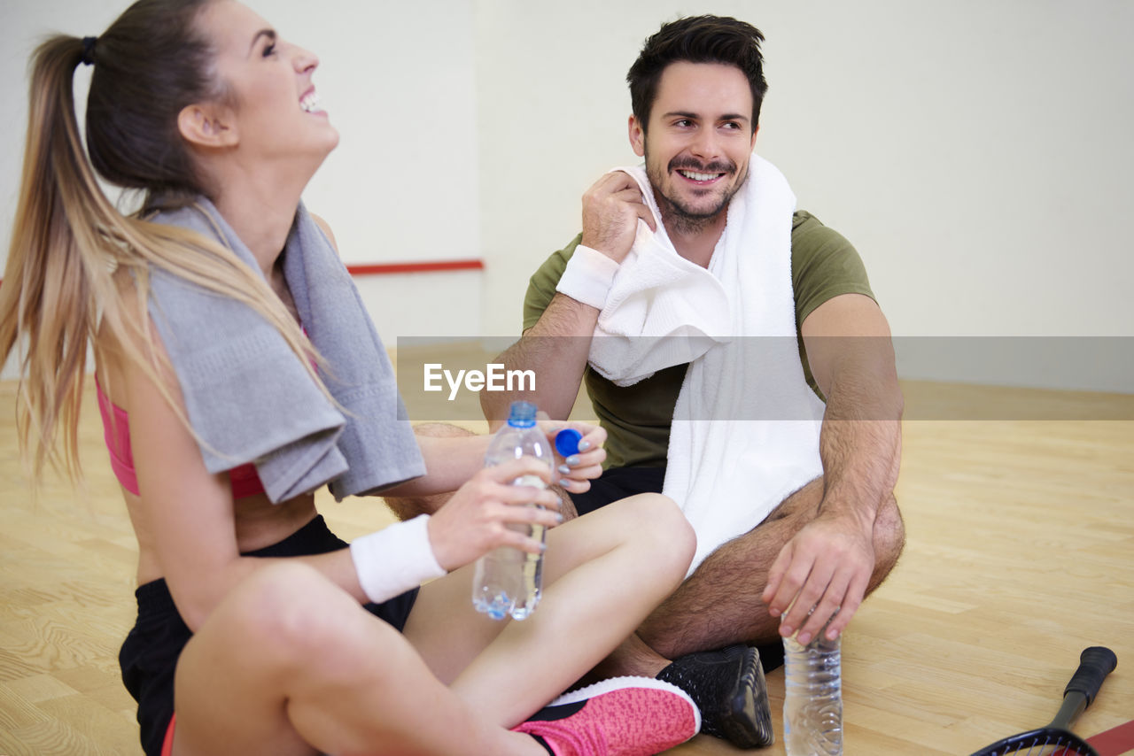 Smiling friends sitting on court