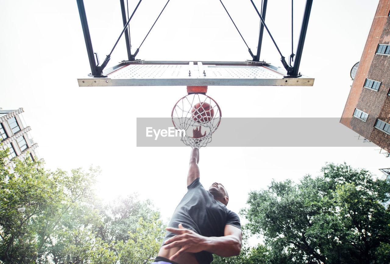 Low angle view of young man playing basketball